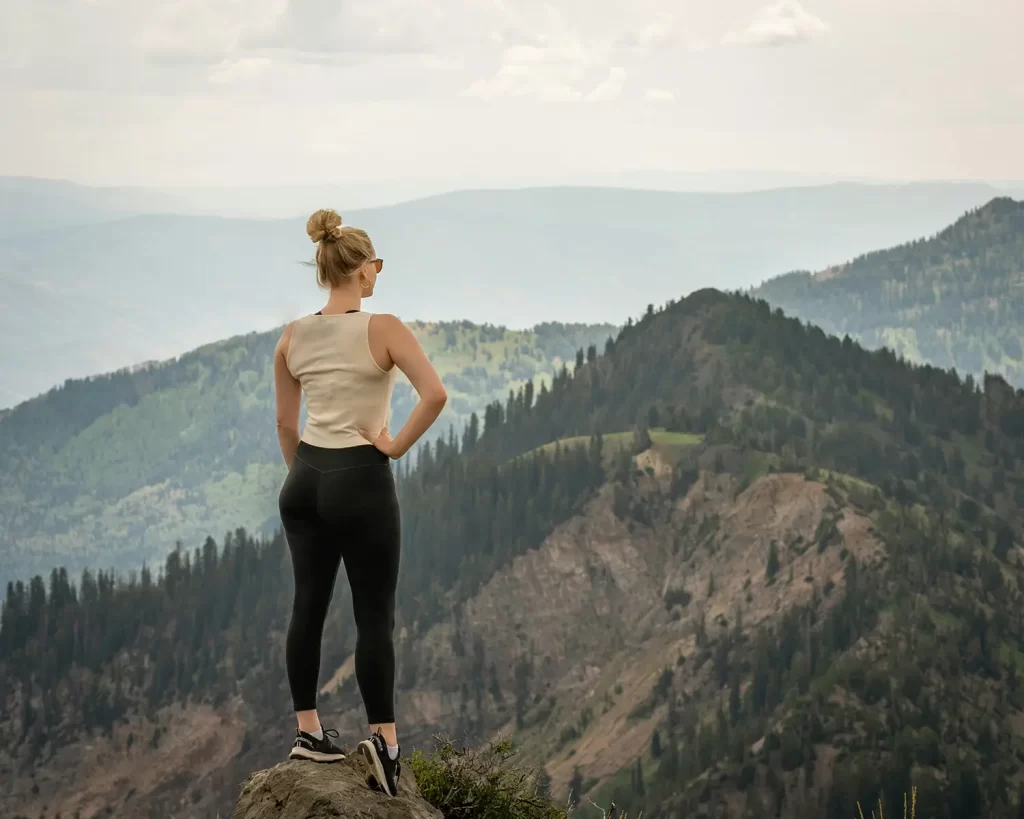 Woman on top of mountain after regaining energy with Epstein Barr virus recovery.