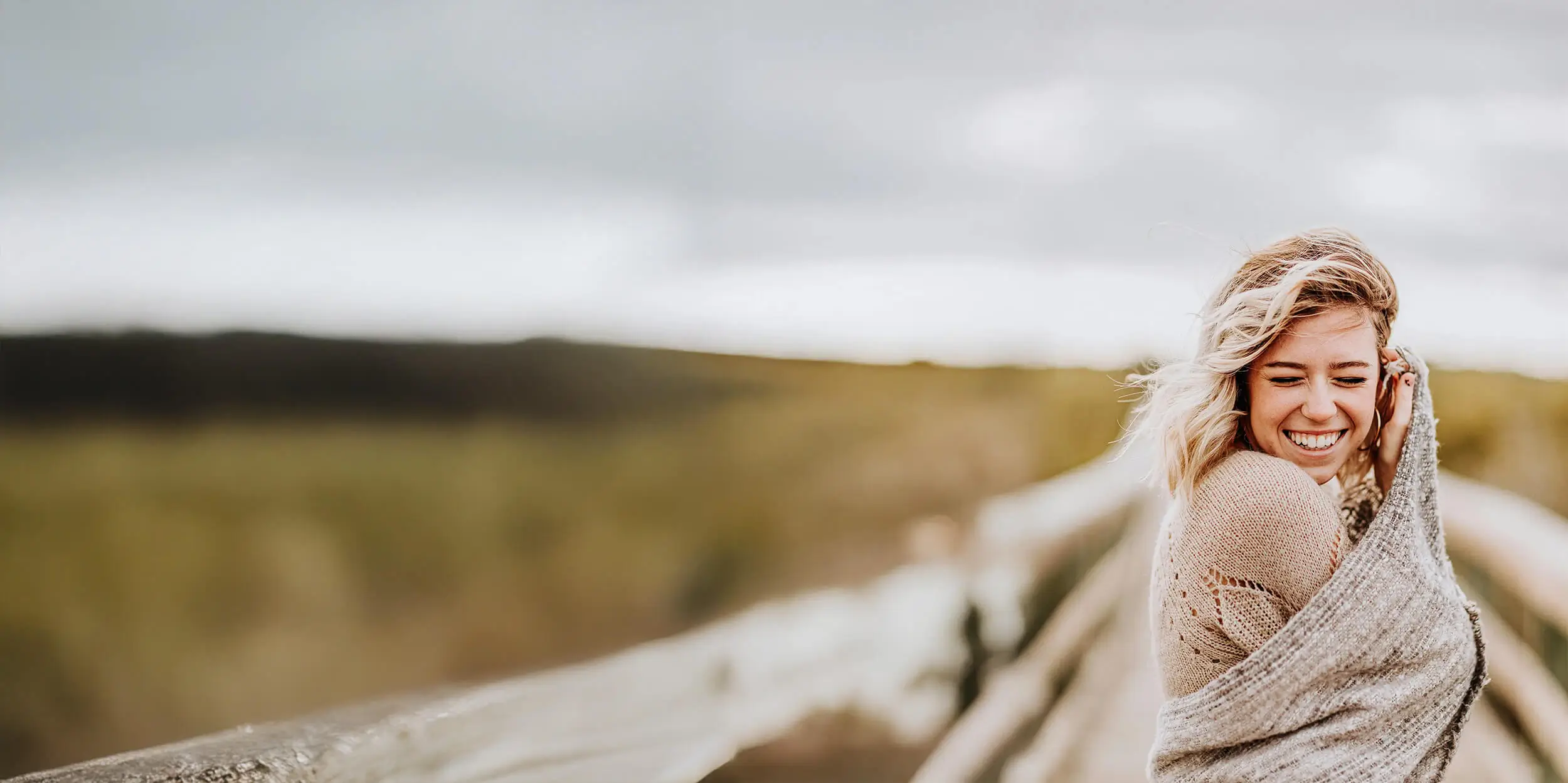 Woman smiling outside in field after healing from mold toxicity with Dr. Kasey Holland.